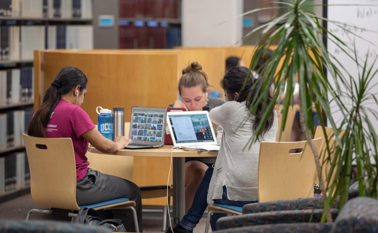students working on their computers in the library
