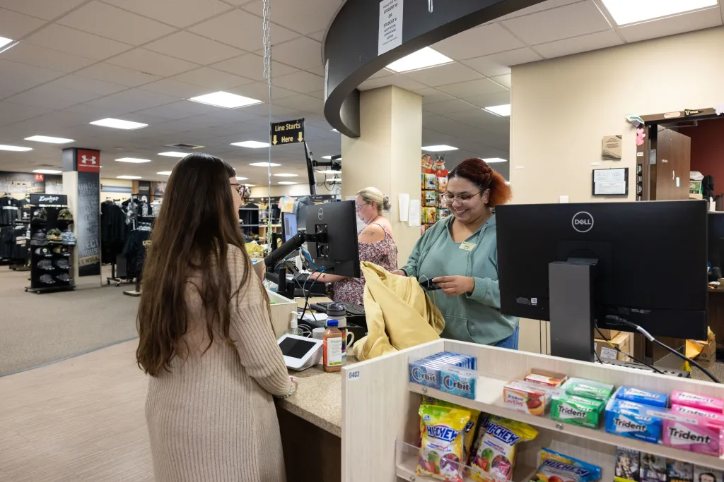 Student Employee helping a customer in the UCCS bookstore