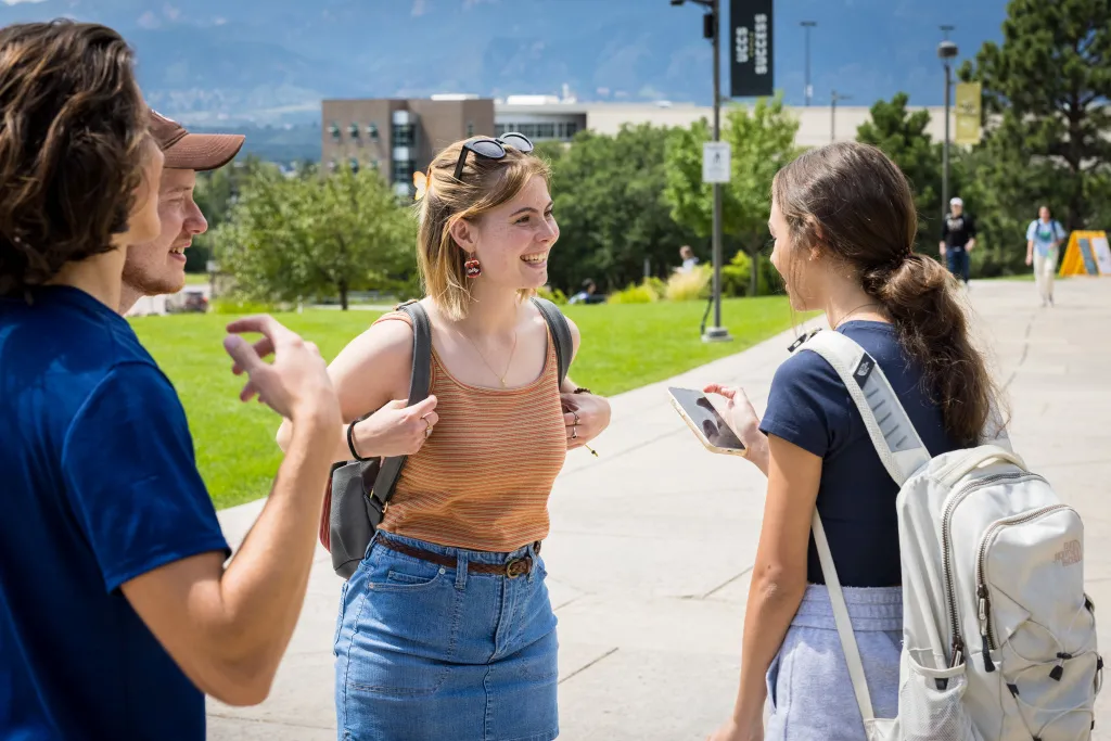 a group of students talking on campus